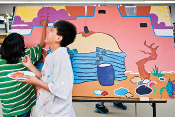 Lemeer Francisco laughs at a joke from classmate Ashley Yamutewa as they work on the Ramah Elementary School class mural in art class Friday.© 2011 Gallup Independent / Cable Hoover 